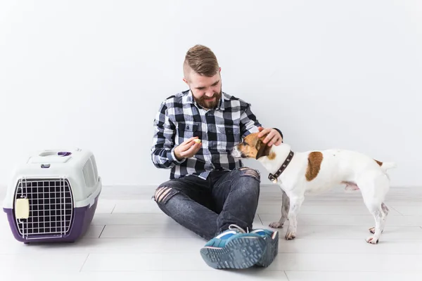 Bolsas de transporte de perros y mascotas concepto de propietario Atractivo hombre alegre en camisa a cuadros tiene mascota favorita. Feliz hombre barbudo con su gato russell terrier — Foto de Stock