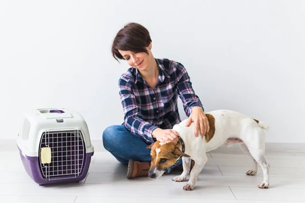 Bolsas de transporte para perros y mascotas concepto de propietario Atractiva hembra alegre en camisa a cuadros tiene mascota favorita. Mujer feliz con su jack russell terrier — Foto de Stock