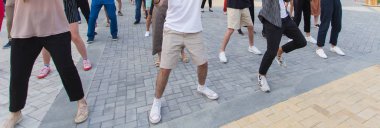 Sosyal dans ve flash mob konsepti. Yazın şehir sokaklarında eğlenmek ve dans etmek. Dansçıların ayaklarına yakın çekim.