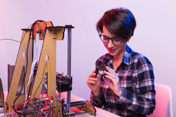 Joven diseñadora ingeniera utilizando una impresora 3D en el laboratorio y estudiando un prototipo de producto, tecnología y concepto de innovación — Foto de Stock