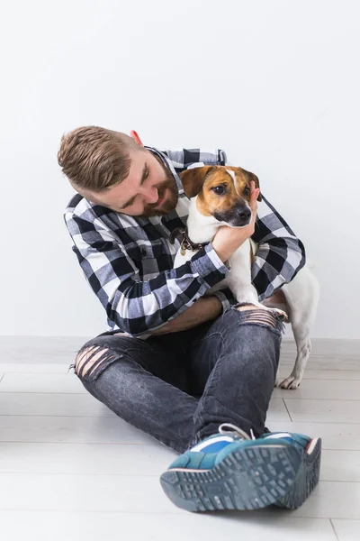 애완 동물 주인 컨셉 - 화려 한 셔츠를 입은 매력적 인 쾌활 한 수컷 이 가장 좋아 하는 애완 동물을 들고 있다. 잭 러셀 테리어와 함께 행복 한 수염을 기른 사람 — 스톡 사진
