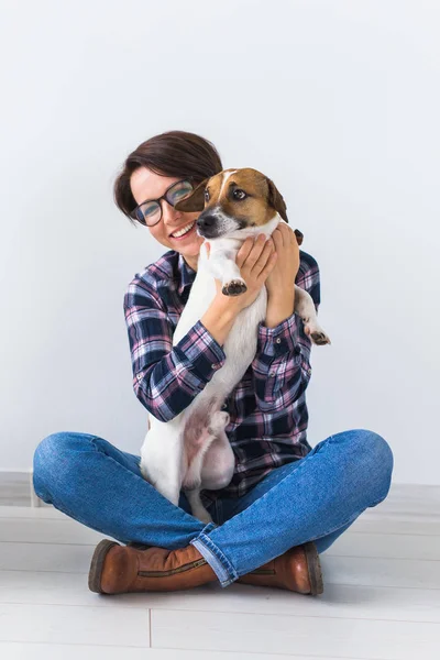 애완 동물 주인 컨셉 - 화려 한 셔츠를 입은 매력적 인 쾌활 한 암컷 이 가장 좋아 하는 애완 동물을 들고 있다. 잭 러셀 테리어와 함께 한 행복 한 여자 — 스톡 사진