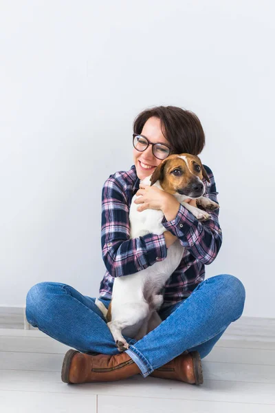 애완 동물 주인 컨셉 - 화려 한 셔츠를 입은 매력적 인 쾌활 한 암컷 이 가장 좋아 하는 애완 동물을 들고 있다. 잭 러셀 테리어와 함께 한 행복 한 여자 — 스톡 사진