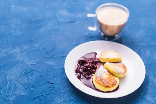 Завтрак и вкусная концепция - Блинчики из творога с джемом, синий фон . — стоковое фото