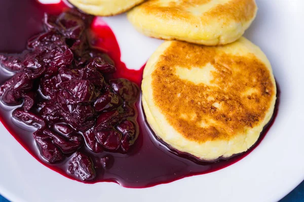 stock image Cottage cheese pancakes with cherry jam, close up, top view.