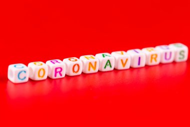 Salgın hastalık ve virüs kavramı. Renkli bloklardan yapılmış Coronavirus kelimesi. Kırmızı arkaplanda Coronavirus metni. Coronavirus konsepti üst görünüm.