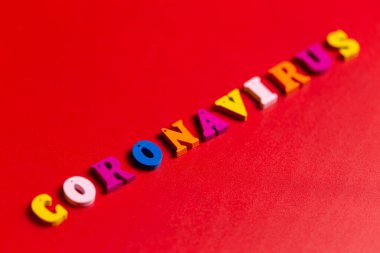 Salgın hastalık ve virüs kavramı. Renkli bloklardan yapılmış Coronavirus kelimesi. Kırmızı arkaplanda Coronavirus metni. Coronavirus konsepti üst görünüm.