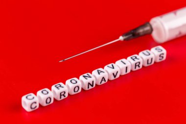 Pandemik ve virüs kavramı - Coronavirus metni ve kırmızı arka planda şırınga. Roman Coronavirus Covid-19.