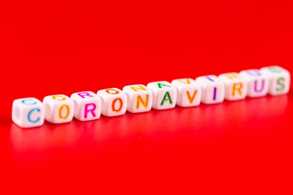 Concetto di pandemia e virus - parola Coronavirus fatta di blocchi colorati. Testo di Coronavirus su sfondo rosso. Concetto Coronavirus vista dall'alto . — Foto Stock