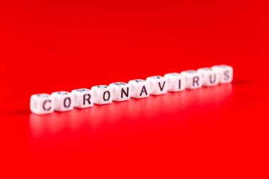 Pandemik ve virüs kavramı, beyaz bloklardan yapılmış Coronavirus kelimesi. Kırmızı arkaplanda Coronavirus metni.