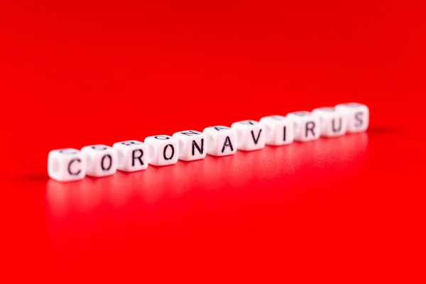 Koncepcja pandemii i wirusa - słowo koronawirusa wykonane z białych klocków. Tekst koronawirusa na czerwonym tle. — Zdjęcie stockowe
