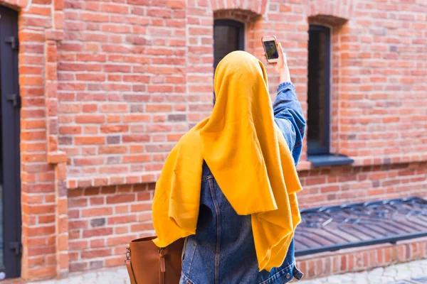 Sprzedaż, technologie i koncepcja zakupu - Szczęśliwa arabska muzułmanka robi selfie na świeżym powietrzu po zakupach — Zdjęcie stockowe