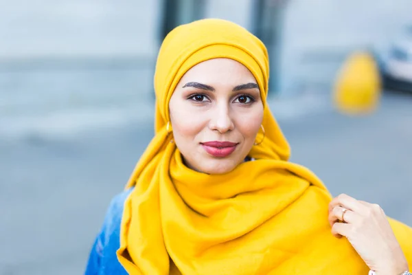 Vacker arabisk muslimsk kvinna bär gul hijab, elegant kvinnligt ansikte porträtt över stadens gata. — Stockfoto