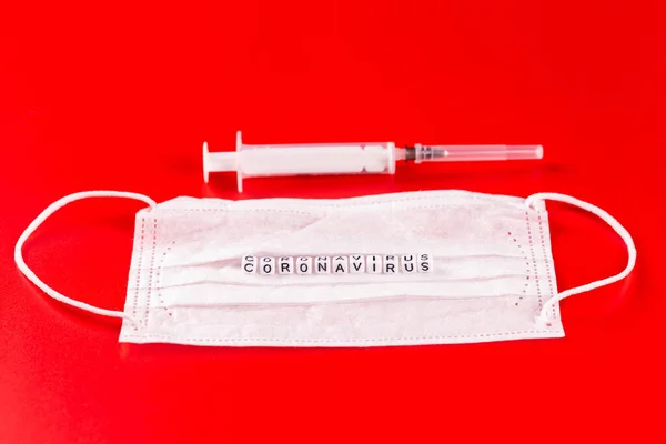 Palabra de Coronavirus hecha de letras sobre fondo rojo. La inscripción en la máscara protectora médica coronavirus . —  Fotos de Stock