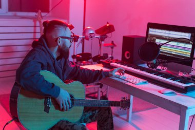 Müzik ve stüdyo konsepti yaratmak - sakallı adam gitarist ev stüdyosunda elektro gitar kaydı yapıyor