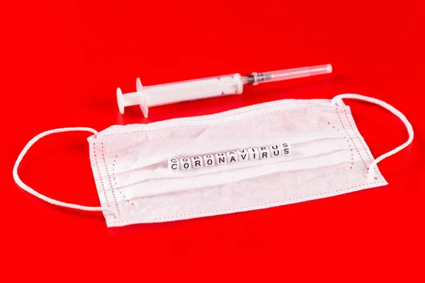 Palabra de Coronavirus hecha de letras sobre fondo rojo. La inscripción en la máscara protectora médica coronavirus . —  Fotos de Stock