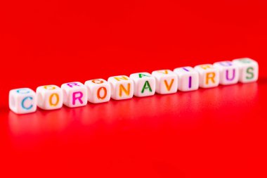 Salgın hastalık ve virüs kavramı. Renkli bloklardan yapılmış Coronavirus kelimesi. Kırmızı arkaplanda Coronavirus metni. Coronavirus konsepti üst görünüm.