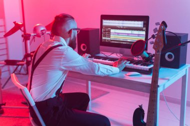 Evdeki dijital stüdyoda profesyonel müzisyen kayıt sentezleyicisi, müzik üretim teknolojisi konsepti.