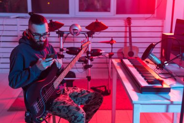 Profesyonel müzisyen gitarı dijital stüdyoda kaydediyor. Müzik prodüksiyon teknolojisi konsepti..
