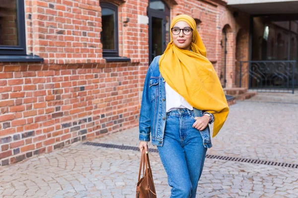 Mulher muçulmana árabe bonita vestindo hijab amarelo, retrato feminino elegante sobre a rua da cidade . — Fotografia de Stock