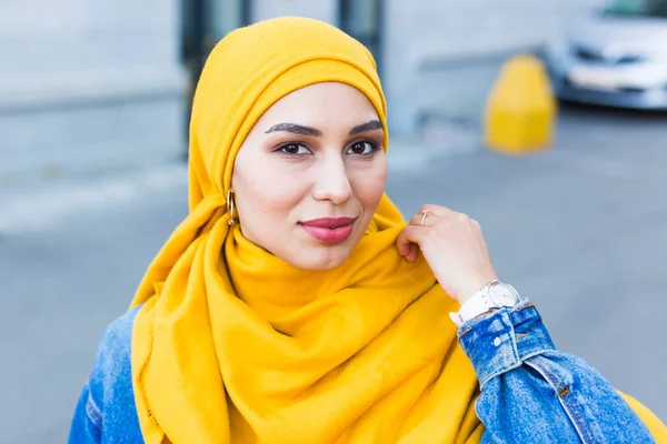 Vacker arabisk muslimsk kvinna bär gul hijab, elegant kvinnligt ansikte porträtt över stadens gata. — Stockfoto