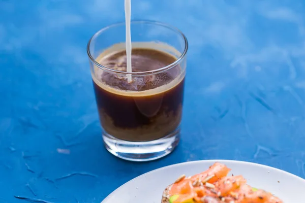 Concepto de mañana y desayuno: verter la crema en una taza de café — Foto de Stock