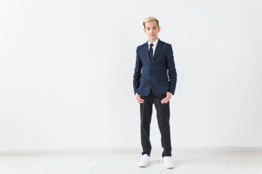 Beyaz gömlekli ve ceketli şık okul çocuğunun portresi beyaz arka planda fotokopi alanı olan.