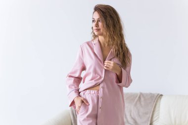 Güzel renkli pijama giymiş, oturma odasında model kılığına girmiş çekici bir kadın. Rahat uyku giysileri, ev rahatlığı ve kadın moda konsepti..