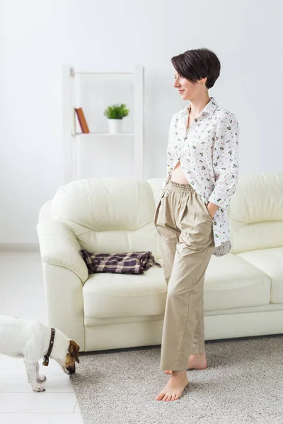 Jonge aantrekkelijke vrouw gekleed in prachtige kleurrijke pyjama die zich voordoet als model in haar woonkamer. Comfortabele slaapkledij, huisontspanning en vrouwelijk modeconcept. — Stockfoto