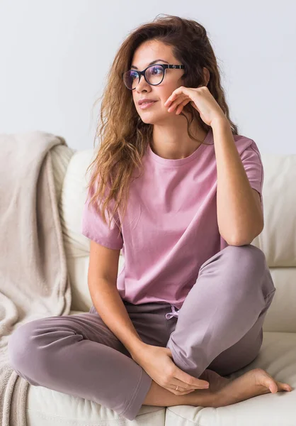 Güzel renkli pijama giymiş, oturma odasında model kılığına girmiş çekici bir kadın. Rahat uyku giysileri, ev rahatlığı ve kadın moda konsepti..