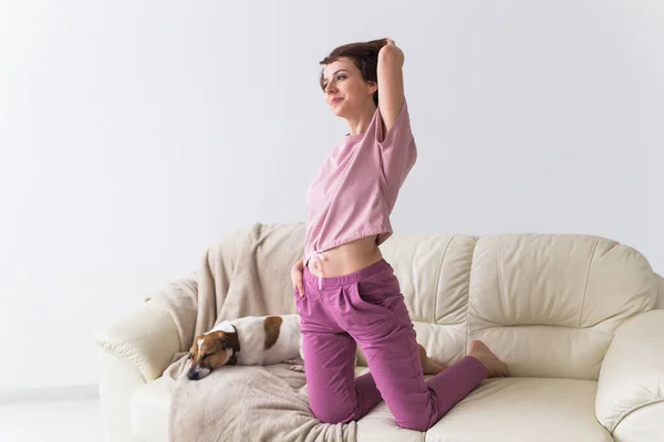 Jonge aantrekkelijke vrouw gekleed in prachtige kleurrijke pyjama die zich voordoet als model in haar woonkamer. Comfortabele slaapkledij, huisontspanning en vrouwelijk modeconcept. — Stockfoto