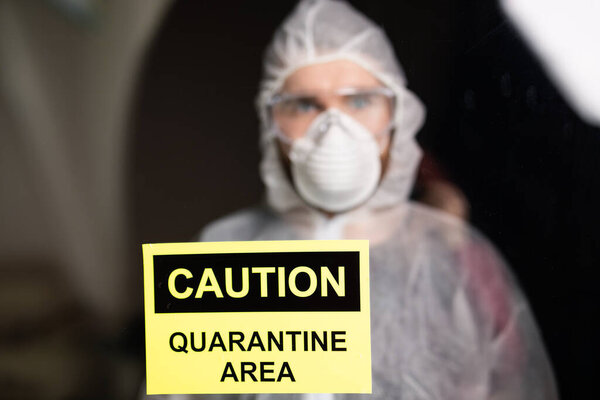 Человек в защитном белом комбинезоне, маске и очках на лице. Коронавирус, пандемия, грипп и карантин
.