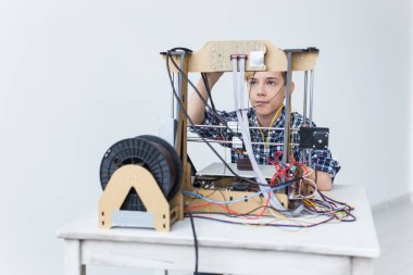 Eğitim, çocuklar, teknoloji konsepti - genç çocuk 3D yazıcı kullanıyor.