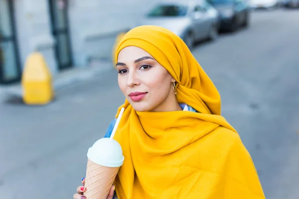 Jovem bela mulher árabe em hijab beber cocktail de refrigeração ao ar livre . — Fotografia de Stock