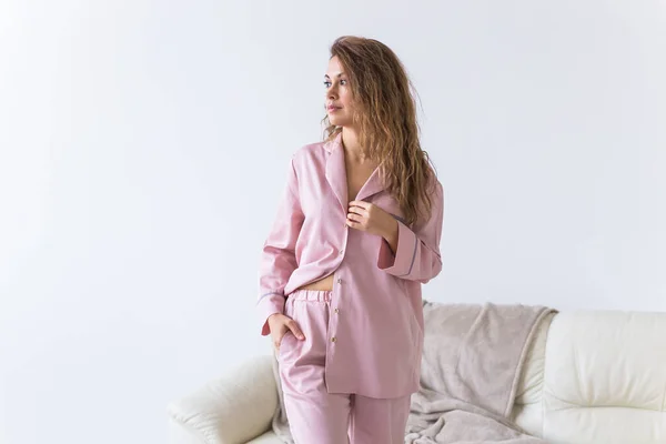 Jonge aantrekkelijke vrouw gekleed in prachtige kleurrijke pyjama die zich voordoet als model in haar woonkamer. Comfortabele slaapkledij, huisontspanning en vrouwelijk modeconcept. — Stockfoto