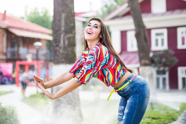 Schöne attraktive junge Frau hat Spaß und genießt und tanzt im Park an einem sonnigen Sommertag. — Stockfoto