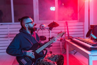 Profesyonel müzisyen gitarı dijital stüdyoda kaydediyor. Müzik prodüksiyon teknolojisi konsepti..