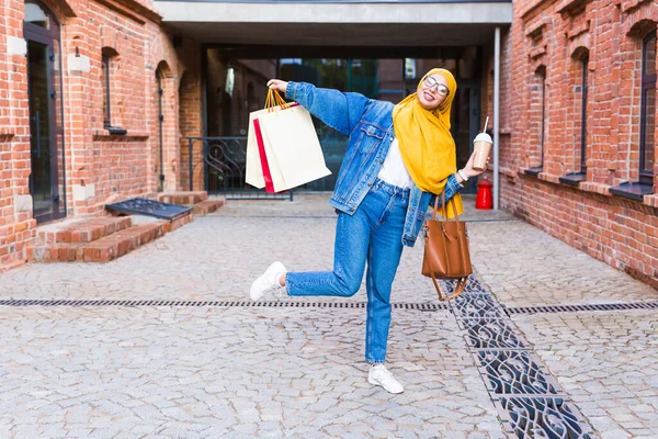 Försäljning och köp koncept - Glad rolig arabisk muslim flicka med shoppingväskor efter köpcentret — Stockfoto