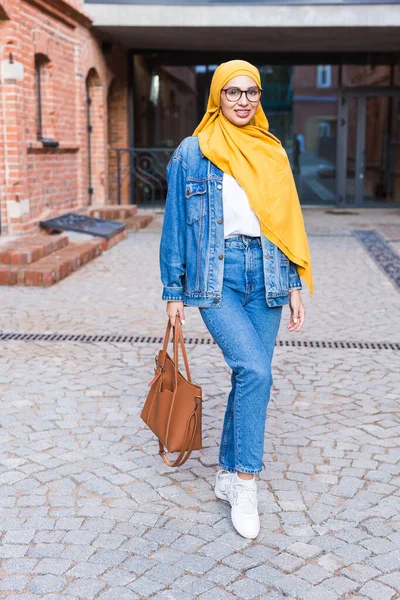 Sarı başörtüsü takan güzel Arap Müslüman öğrenci kadın, şehrin caddesinde şık bir kadın portresi. — Stok fotoğraf