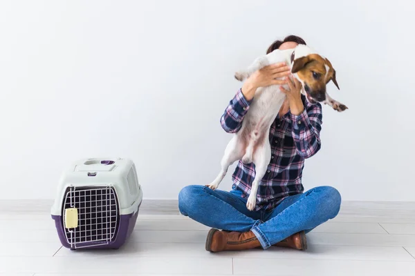 Bolsas de transporte para perros y mascotas concepto de propietario Atractiva hembra alegre en camisa a cuadros tiene mascota favorita. Mujer feliz con su jack russell terrier — Foto de Stock