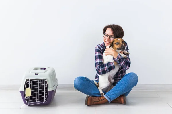 Bolsas de transporte para perros y mascotas concepto de propietario Atractiva hembra alegre en camisa a cuadros tiene mascota favorita. Mujer feliz con su jack russell terrier — Foto de Stock