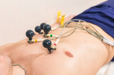Tıp, sağlık ve kalp kontrolü konsepti - Hastanede ECG elektrokardiyogramı olan erkek hasta