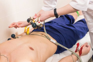 Tıp, sağlık ve kalp kontrolü konsepti - Hastanede ECG elektrokardiyogramı olan erkek hasta