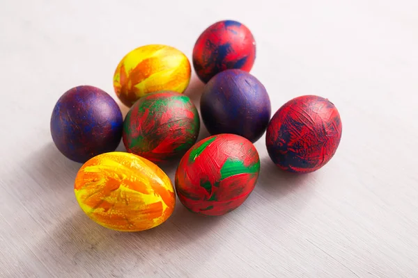 Dovolená, tradice a velikonoční koncept - pestrobarevná dekorativní barevná vejce na bílém pozadí. Horní pohled. — Stock fotografie