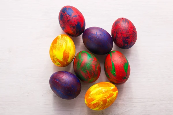 Vacaciones, tradiciones y concepto de Pascua: huevos coloridos decorativos multicolores sobre fondo blanco. Vista superior . —  Fotos de Stock