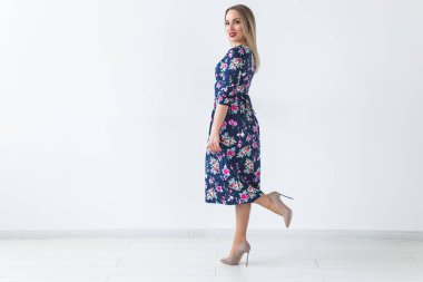 Güzel yazlık elbiseli şık sarışın kadın, beyaz stüdyoda fotokopi çekiyordu..