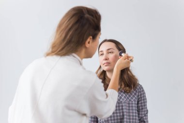 Güzellik ve kozmetik konsepti - Makyaj sanatçısı genç bir kadından profesyonel makyaj yapıyor