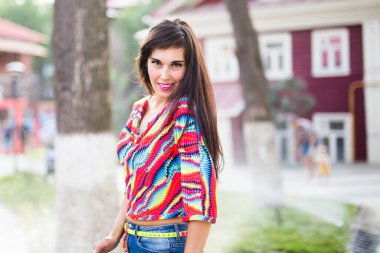 Güzel, çekici genç bir kadın güneşli bir yaz gününde parkta eğleniyor, eğleniyor ve dans ediyor..