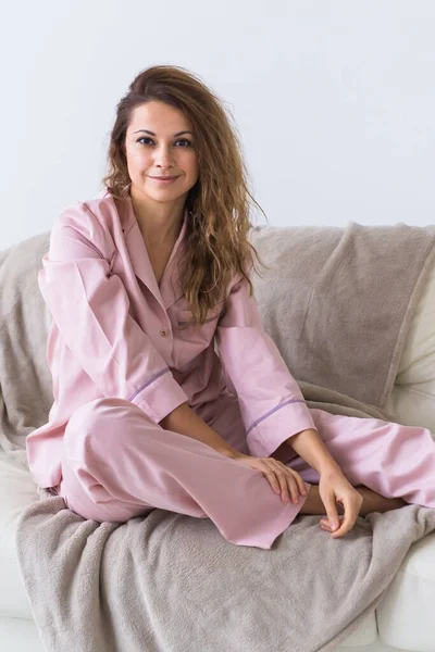 Jovem mulher atraente vestida em belo pijama colorido posando como um modelo em sua sala de estar. Confortável sleepwear, relaxamento em casa e conceito de moda feminina . — Fotografia de Stock