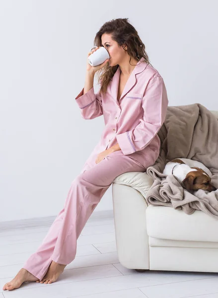Jonge aantrekkelijke vrouw gekleed in prachtige kleurrijke pyjama die zich voordoet als model in haar woonkamer. Comfortabele slaapkledij, huisontspanning en vrouwelijk modeconcept. — Stockfoto